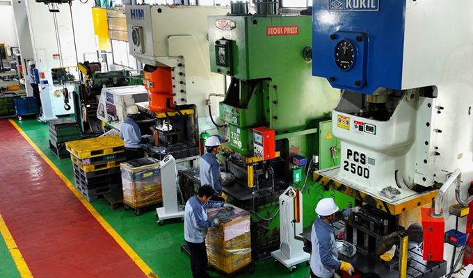 Workers at Dawoo Technology's factory press line are producing car parts.